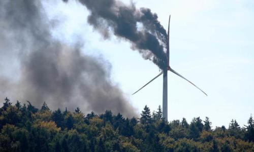brennendes Winrad mit Wald im Vordergrund