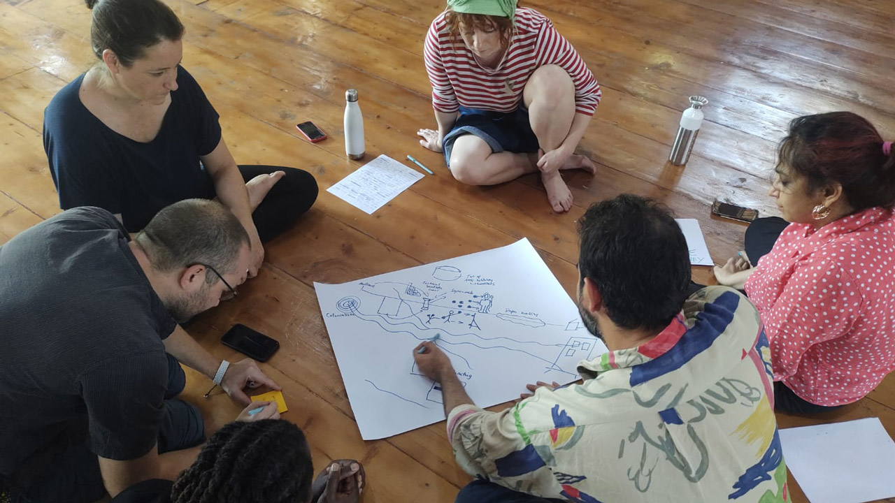Flinnworks Team sitzt auf dem Boden und machen Skizzen